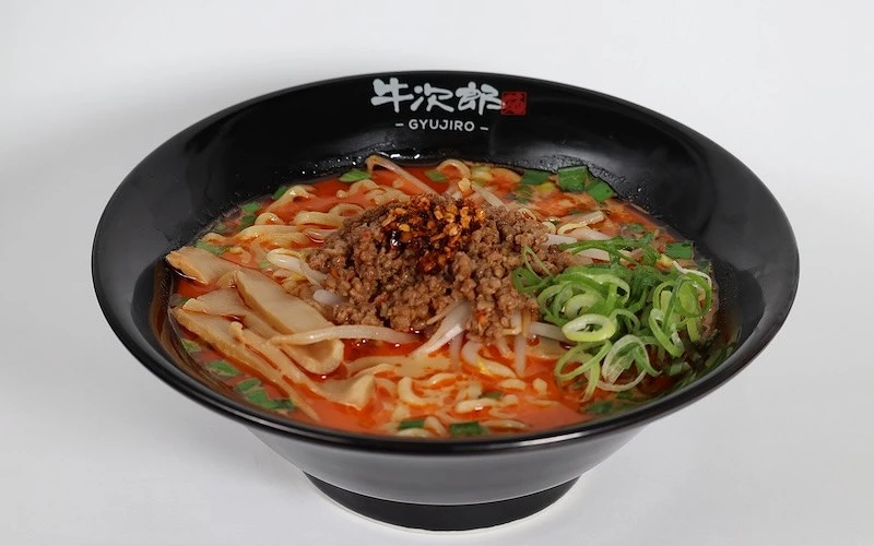 一碗紅色湯底，且鋪有肉燥、豆芽菜、蔥花和筍乾的拉麵