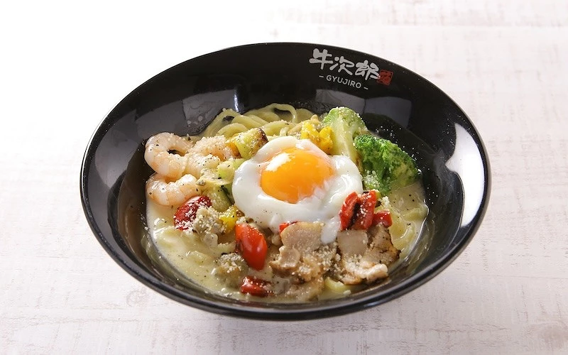 一碗有肉片、半熟蛋、蝦子、番茄、花椰菜的義大利麵