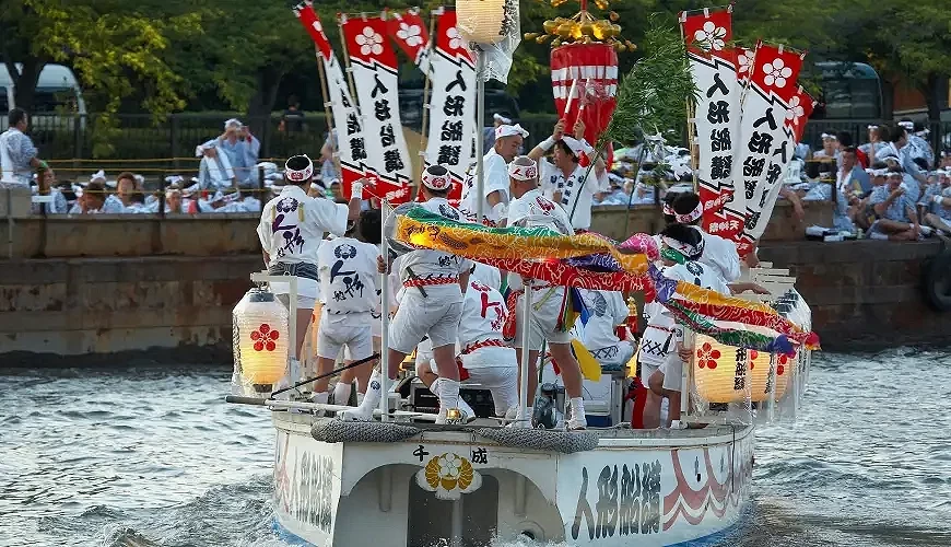 大阪天神祭船渡御活動,參與者身穿傳統服飾在裝飾華麗的船上遊行