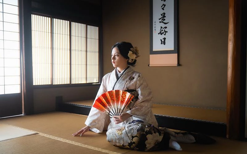 一位穿著和服的女性手拿紅色扇子