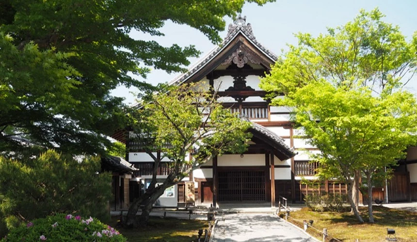 京都高台寺的入口建築與庭園景色,融合枯山水與日式木造建築,周圍綠意盎然,展現寧靜和雅的禪意氛圍,為紀念豐臣秀吉而建的歷史名寺。