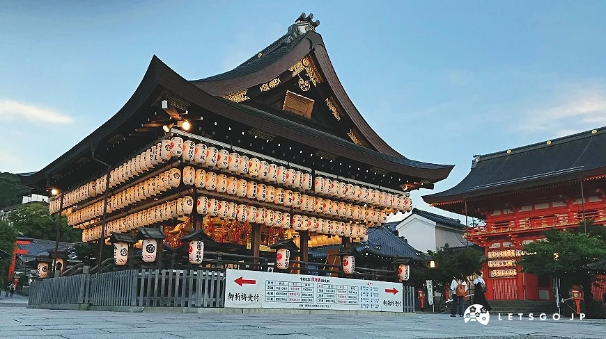 京都名所「八坂神社」在傍晚時刻的景象,境內提燈與八坂神社燈籠亮起,充滿神聖的氣氛。