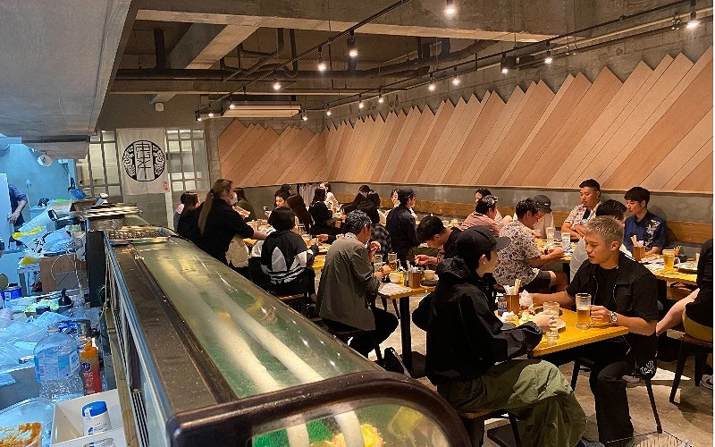 餐廳內多組客人坐滿用餐,桌上擺有飲料與餐點