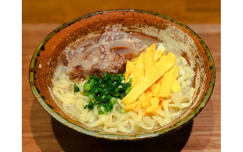 碗中盛有麵條,配料包括豬軟骨、青蔥與蛋絲