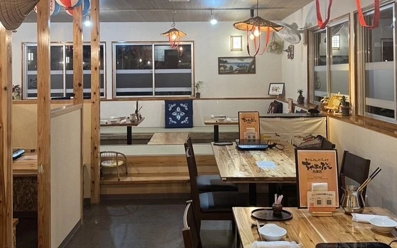 餐廳內部木質裝潢,桌椅擺放整齊,設有和室座位區