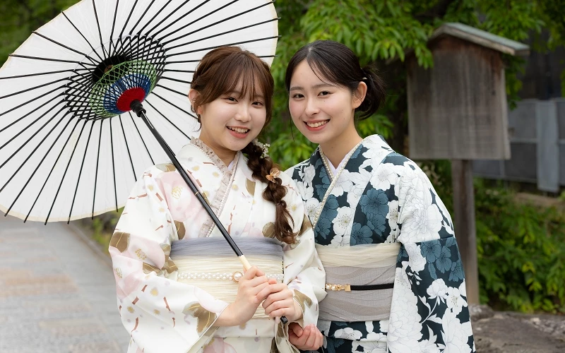 兩位女性穿著和服,其中左邊的女性拿著紙傘