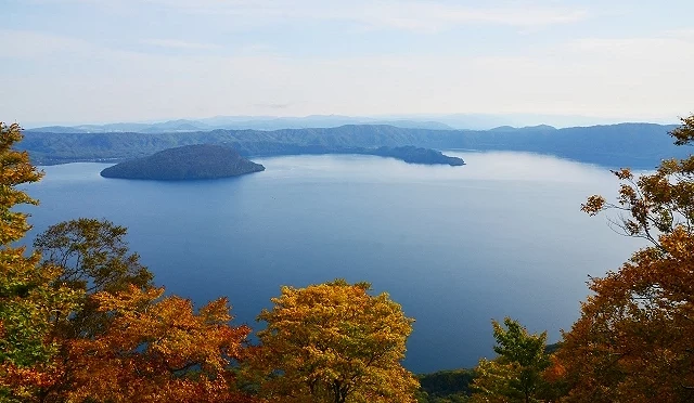 秋季十和田湖,湖面寧靜如鏡,四周群山紅葉染色