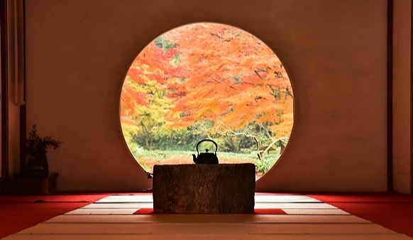 鎌倉明月院丸窗映出滿庭紅葉,榻榻米室內茶壺剪影襯托秋日禪意