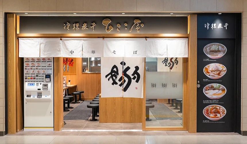 來自青森的津軽hirako屋魚干系拉麵,店外擺放白色自動食卷販賣機,以高貴優雅的黑色作為店家主視覺,還有四碗拉麵作為招牌視覺點綴