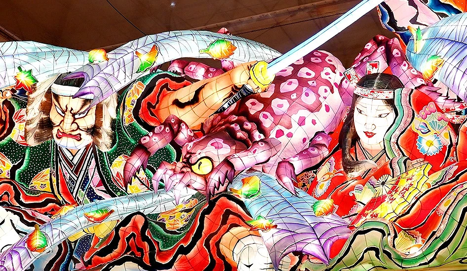 日本祭典上五彩繽紛的大型花燈,描繪武士揮舞寶劍與妖怪戰鬥的場景