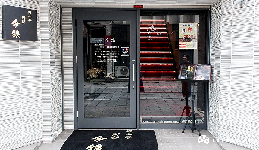 店面入口玻璃門上貼有營業時間,旁邊立有菜單架