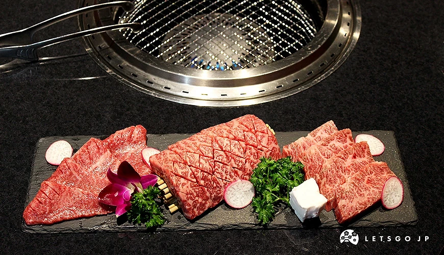 燒肉爐前放置一盤切片和牛肉,旁邊裝飾蘿蔔片與花朵