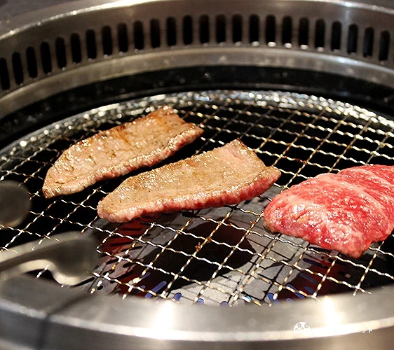 烤網上兩片熟牛肉與一片生牛肉並排加熱