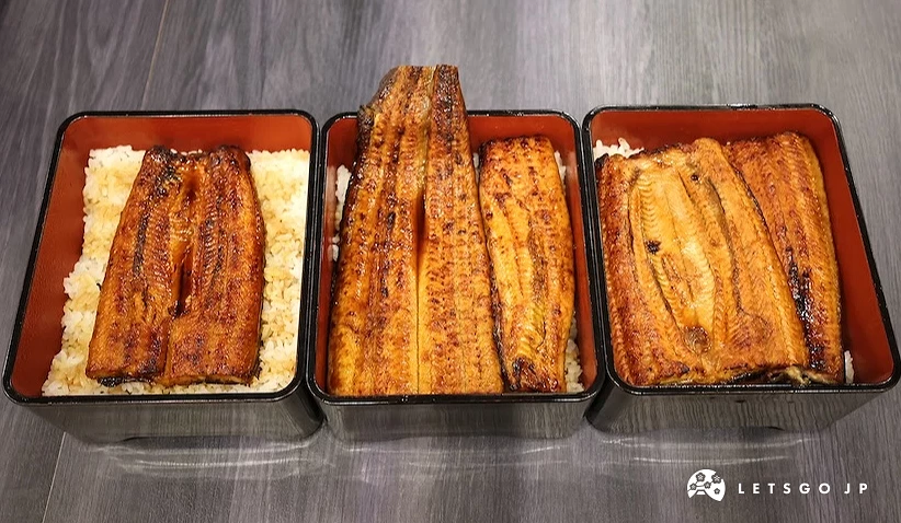 三個長方形餐盒內盛裝白飯與烤鰻魚