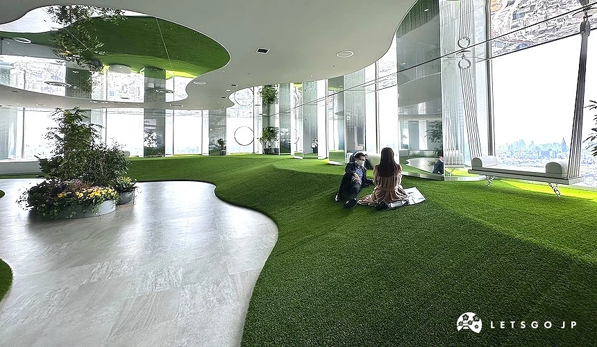 一對男女坐臥在綠色的展望之丘上