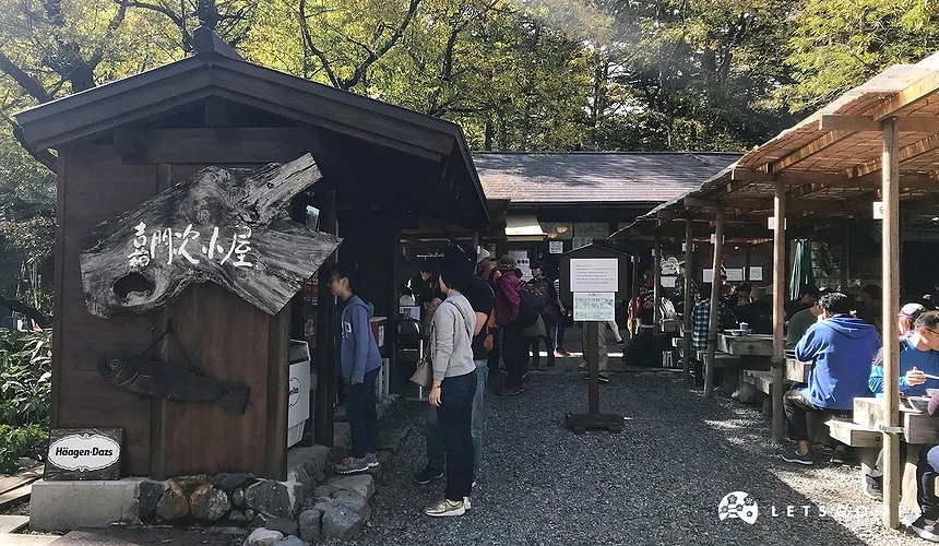 寫著「嘉門次小屋」的木造建築,有一些人在吃飯