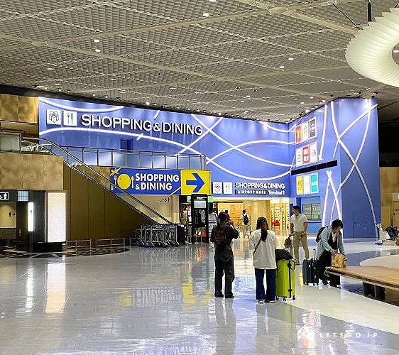 成田機場航廈內的「SHOPPING & DINING」區域入口,設有清楚指標與明亮裝潢,旅客可在此購物、用餐或休息