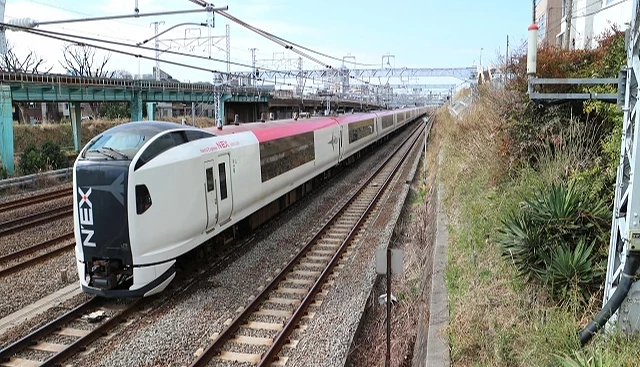 成田特快 N’EX 列車行駛在鐵道上,從成田機場往東京方向的途中