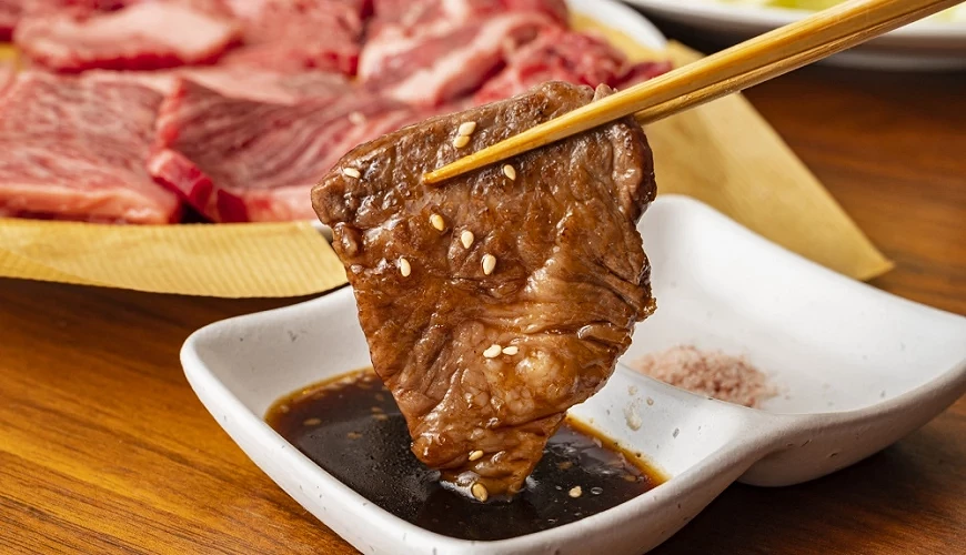 以筷子夾肉蘸醬