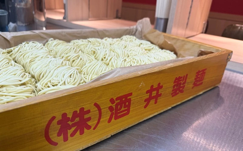 一團團麵條整齊擺放在木箱中側邊有酒井製麵文字