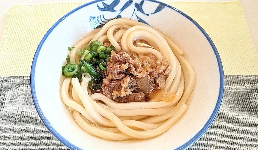 一碗放有牛肉與蔥花的烏龍麵
