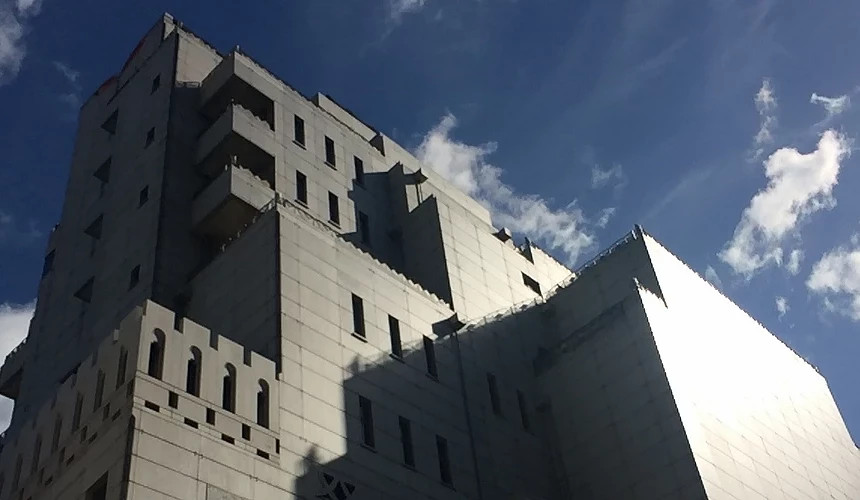 藍天下灰白色現代建築外觀,線條方正帶有城堡風格