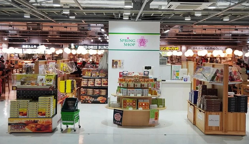 成田機場第三航廈2樓「SPRING SHOP 春」商店,陳列各式日本伴手禮與甜點,後方為美食廣場與多家餐廳座位區
