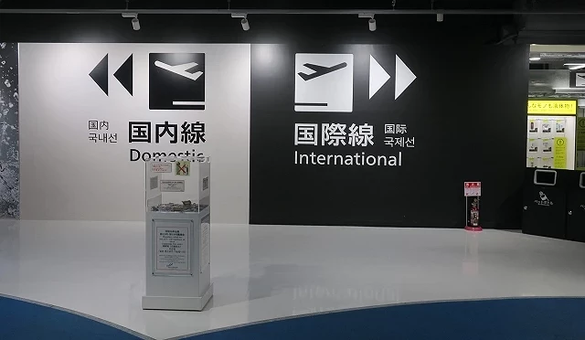 成田機場第三航廈內部牆面標示,左側為「國內線 Domestic」,右側為「國際線 International」,黑白對比設計讓旅客清楚辨識登機方向