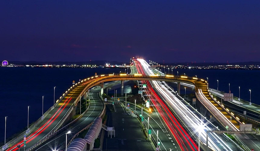 夜色中車流奔馳於東京灣跨海高速道路,燈光軌跡勾勒出壯觀景象。