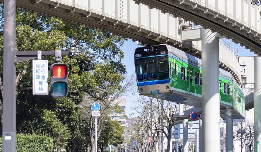 懸掛於軌道下方行駛的綠色千葉都市單軌電車。