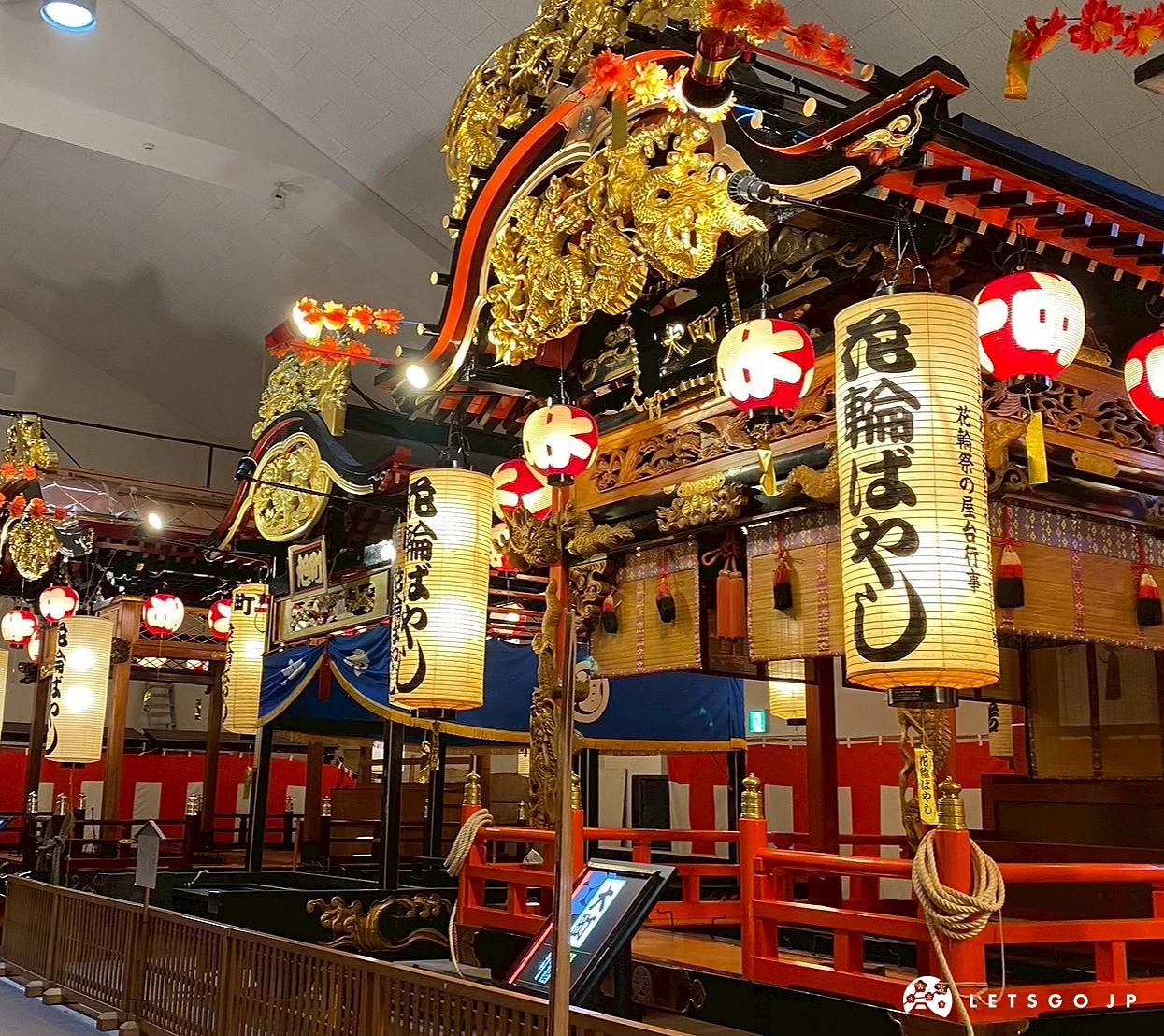 室內展場中一個巨大、裝飾著燈籠和金色裝飾的日本傳統祭典屋台。