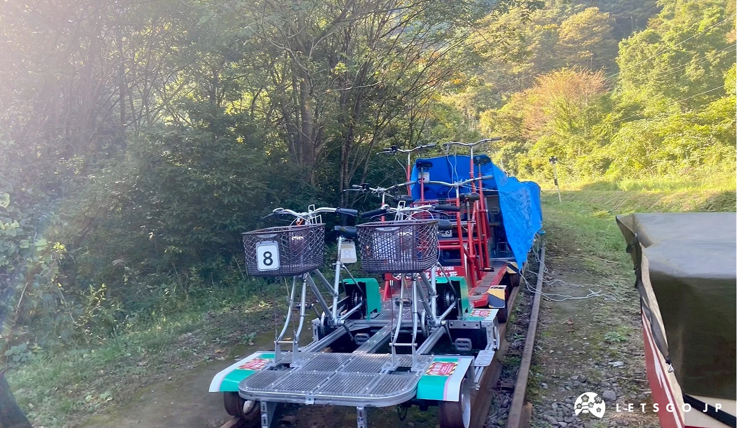 一輛藍色和黃色的鐵軌自行車停在鐵軌
