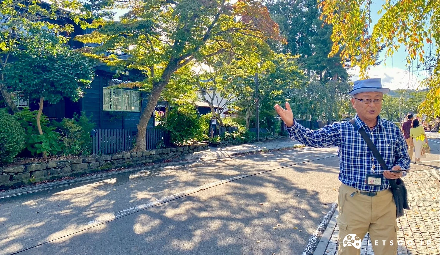 導遊站在角館武家屋敷區一扇傳統日式木門前。