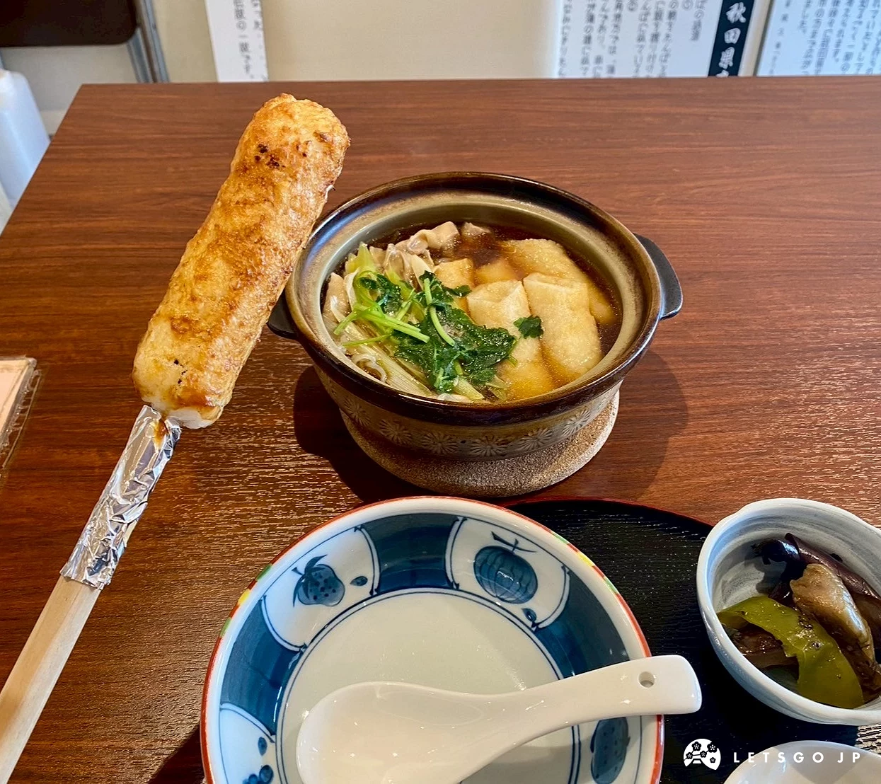 一碗熱騰騰的日式烤米棒鍋,配上米飯和漬物。