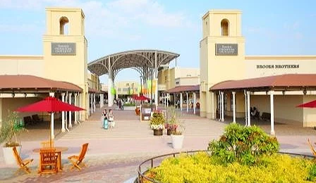 酒酒井Premium Outlets 購物中心內景,設有遮陽傘座椅與歐風建築通道。