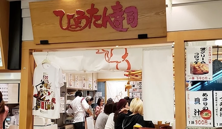 葫蘆迴轉壽司店門口可以看到滿坐的店內,門口上方是紅色字體的LOGO配上木質調招牌
