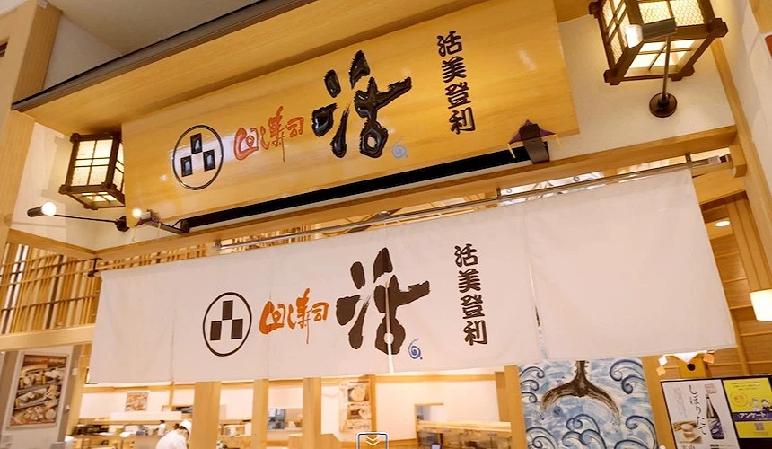 活美登利店門口,淺色木頭牆及白色布簾,logo是大大的「活」書法字