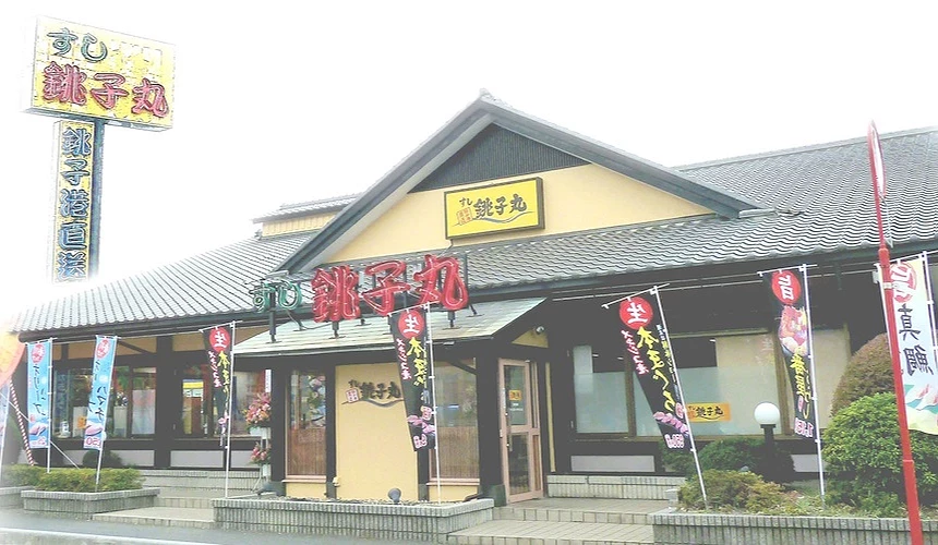 銚子丸本店是一間獨棟建築,日式屋瓦搭配黃色招牌,及紅色大字的霓虹燈logo