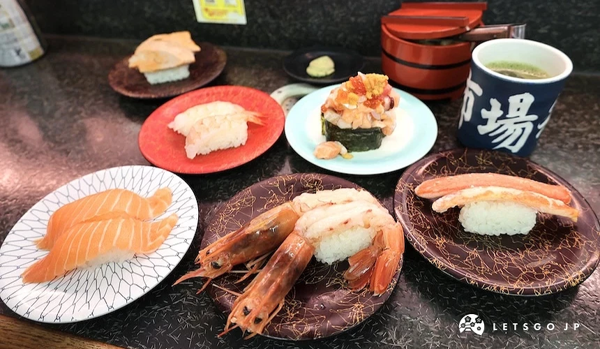 餐桌上放了數盤壽司及茶杯