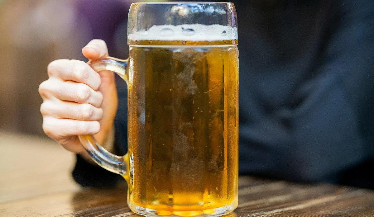 特寫一大杯充滿冰涼金黃色液體和白色泡沫的生啤酒。