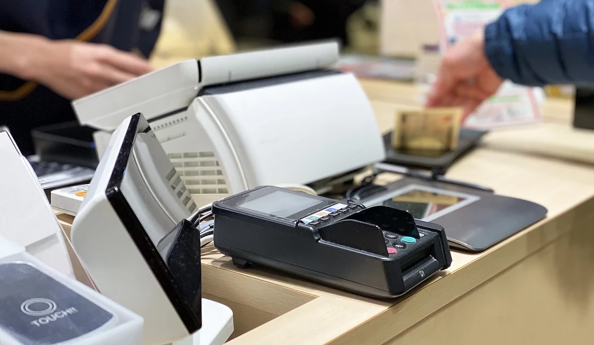 酒屋的結帳櫃檯,顧客正在使用信用卡機進行付費。