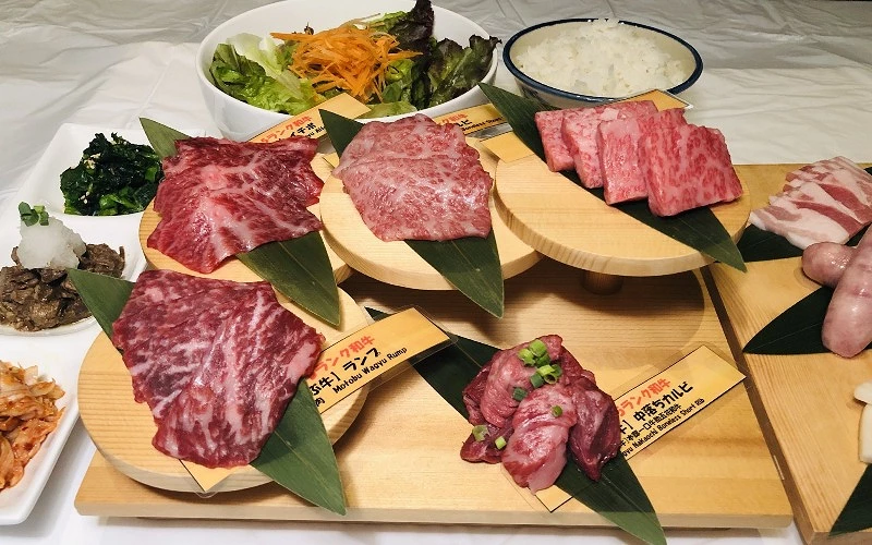 不同部位石垣牛牛肉與配菜擺放於多層木盤上,附生菜與白飯
