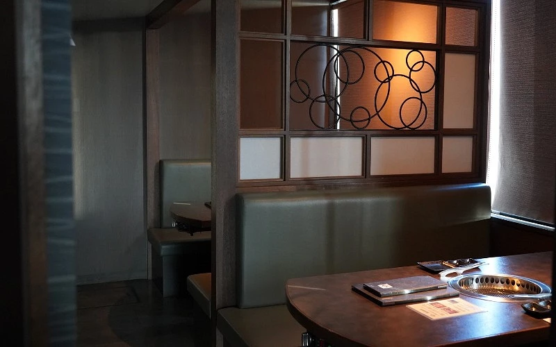 半包廂燒肉座位區,桌上設有內建烤爐與餐具