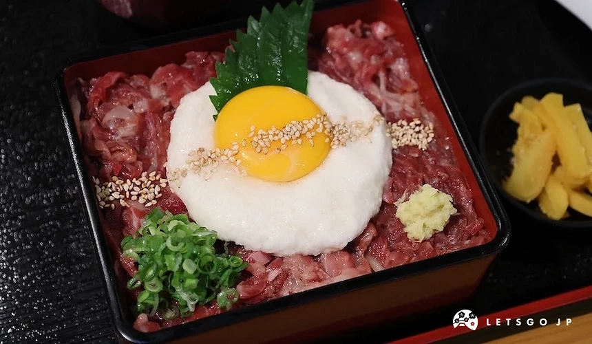 便當盒中舖滿馬肉,上面有山藥與蛋黃