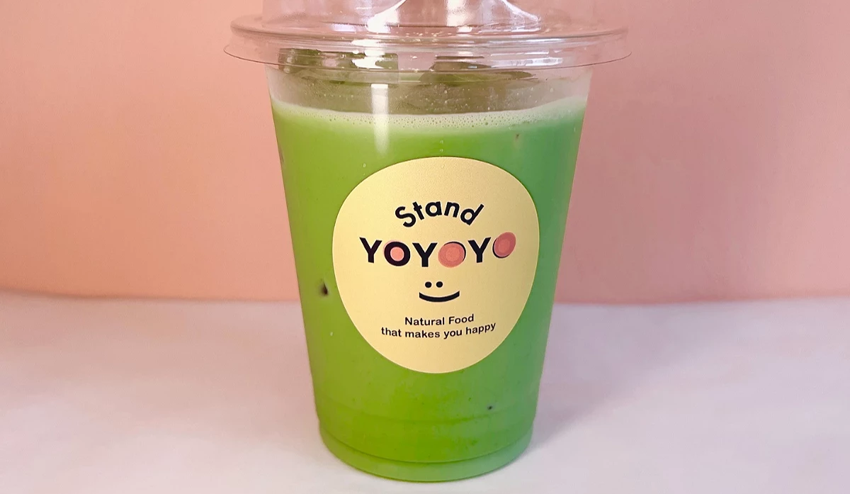 一杯裝在透明外帶杯中的抹茶飲品,杯身貼有 Stand YOYOYO 貼紙。