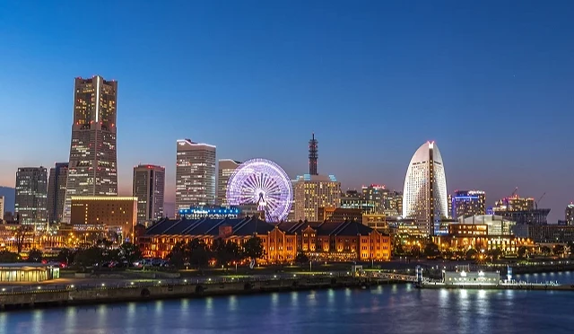 橫濱港灣夜景,包含摩天輪、紅磚倉庫與高樓群燈光倒映在水面上,呈現跨年期間港都的迷人風景