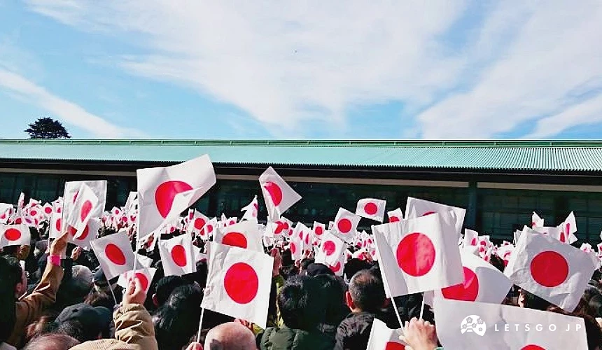 大量民眾在皇居前揮舞日本國旗,排隊參加元旦新年一般參賀活動,背景可見皇居建築與藍天