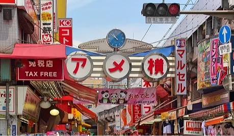 上野阿美橫丁商店街入口掛著大型「アメ横」招牌,街道旁林立各式店舖與看板