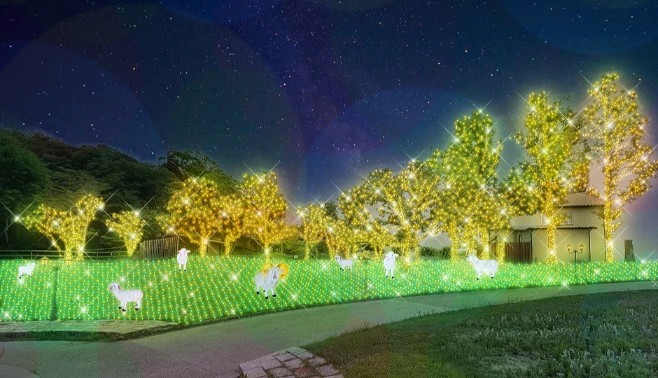 「Wonder Night Hill 2025」放牧區夜景,綠色燈海與金光樹木映襯著水豚與綿羊的可愛燈飾