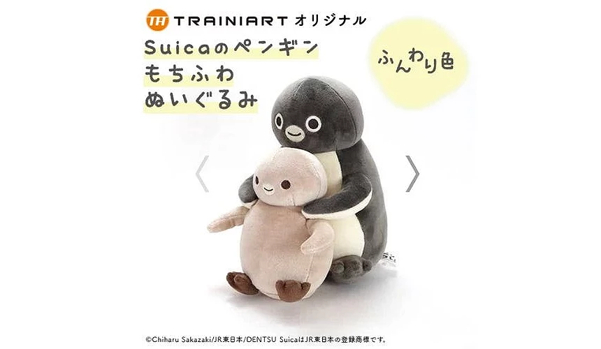 大型 Suica 企鵝絨毛玩偶從後方環抱著一隻小企鵝寶寶,兩者皆為柔軟蓬鬆材質